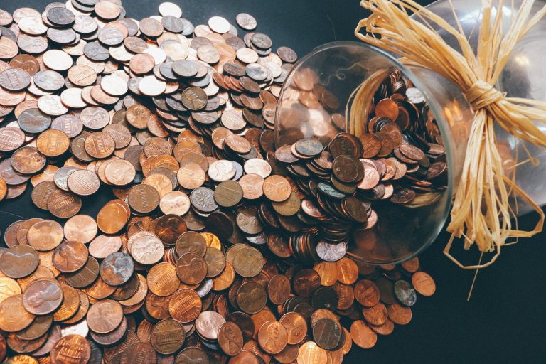 Jar of coins spilled on a table