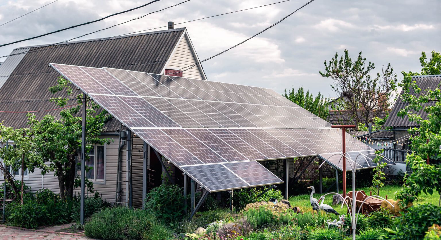 Photo of off-grid solar panels next to a home.