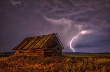 Barn with a lighting strike in the background