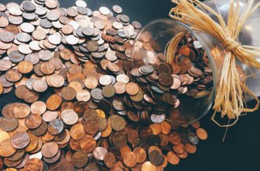 Jar of coins spilled on a table